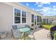Back patio with outdoor seating and a grill, overlooking the sunroom of the home at 1048 Longwood Bluffs Circle, Murrells Inlet, SC 29576
