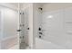 Clean bathroom with a white shower-tub, matte black fixtures, and a door leading to another room at 1061 Edenton Dr., Calabash, NC 28467