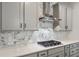 Kitchen featuring custom range hood, white backsplash, and gas cooktop at 1061 Edenton Dr., Calabash, NC 28467