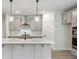 Kitchen island featuring quartz countertop with pendant lighting, stainless appliances and custom cabinetry at 1061 Edenton Dr., Calabash, NC 28467