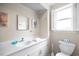 Bright bathroom with a white vanity, decorative accents, and a window with plantation shutters at 1184 Parker Dr., Pawleys Island, SC 29585