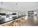 Bright kitchen with white cabinetry, a dark countertop, breakfast bar, and shelving, with light wood floors at 1184 Parker Dr., Pawleys Island, SC 29585