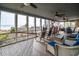 Screened-in porch with ocean views is furnished with a hammock, rocking chairs, and outdoor dining table at 1184 Parker Dr., Pawleys Island, SC 29585