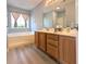 Well-lit bathroom featuring a large vanity, mirror, tub, shower, and stylish wood-look flooring at 119 Brentwood Dr. # D, Murrells Inlet, SC 29576
