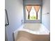 The bathroom offers a deep soaking tub, bright window with curtains, and a safety grab bar at 119 Brentwood Dr. # D, Murrells Inlet, SC 29576