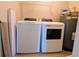 Laundry room with a modern washer, dryer, water heater, and storage space, offering convenience and functionality at 119 Brentwood Dr. # D, Murrells Inlet, SC 29576
