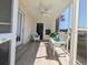 Relax on the screened porch, complete with ceiling fan, comfortable wicker seating, and scenic views at 119 Brentwood Dr. # D, Murrells Inlet, SC 29576