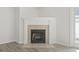 White fireplace surround with neutral tile accents, LVP flooring, and classic trim against the neutral colored walls at 119 Pickerel Blvd., Longs, SC 29568