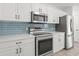 Updated kitchen showcasing stainless steel appliances, white cabinetry, and a complementary backsplash at 119 Pickerel Blvd., Longs, SC 29568
