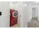 Hallway leading to the laundry room that features a red washer and dryer at 119 Pickerel Blvd., Longs, SC 29568
