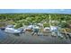 Aerial view displaying a waterfront area with boats docked, buildings, parking, and green trees along a river at 120 Triston Ct., Little River, SC 29566
