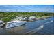 Aerial view showcasing a large boat docked near waterfront buildings and lush green landscape under a partly cloudy sky at 120 Triston Ct., Little River, SC 29566