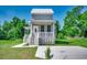 Charming gray two-story home with white trim, porch, and manicured lawn at 120 Triston Ct., Little River, SC 29566