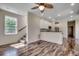Bright living room with ceiling fan, staircase, and view into the modern kitchen at 120 Triston Ct., Little River, SC 29566