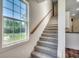 Bright stairway with a large window and wooden banister at 120 Triston Ct., Little River, SC 29566