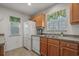 Well-lit kitchen featuring wood cabinets, white appliances, and a double sink under a window at 1249 Shoebridge Dr. # 1249, Myrtle Beach, SC 29579