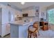 Bright kitchen with white cabinets, modern appliances, and a cozy breakfast bar with seating at 1500 Cenith Dr. # D 103, North Myrtle Beach, SC 29582