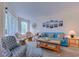 Bright living room featuring a blue sofa, rattan furniture, and beach themed decor at 1500 Cenith Dr. # D 103, North Myrtle Beach, SC 29582