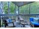 Relaxing screened porch features comfortable seating and a ceiling fan overlooking lush trees at 1500 Cenith Dr. # D 103, North Myrtle Beach, SC 29582