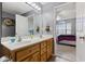 Bathroom featuring double sinks, wooden cabinets, and lots of light, next to the bedroom at 1505 Bramber Pl., Conway, SC 29527