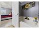 This primary bathroom showcases a clean, modern design with sunflowers artwork and a partially visible bedroom at 1505 Bramber Pl., Conway, SC 29527
