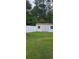 Backyard shed with double doors and windows, surrounded by a white fence and green grass at 1717 Perdiz Covey Ct., Myrtle Beach, SC 29588