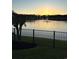 Backyard view of the lake and fountain with an iron fence in the foreground at sunset at 179 Hyacinth Loop, Murrells Inlet, SC 29576