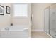 Bright bathroom featuring soaking tub and glass enclosed shower at 179 Hyacinth Loop, Murrells Inlet, SC 29576