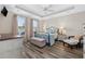 Serene bedroom with tray ceiling, hardwood floors, and lake view from large windows at 179 Hyacinth Loop, Murrells Inlet, SC 29576
