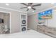 Bright bedroom featuring a ceiling fan, TV, and convenient in-closet washer and dryer at 191 Maison Dr. # B-323, Myrtle Beach, SC 29572