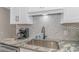 Close-up of kitchen featuring stainless steel sink, and backsplash with white cabinets at 191 Maison Dr. # B-323, Myrtle Beach, SC 29572