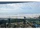 A balcony view of a sandy beach, scattered umbrellas, and lush foliage leading to the ocean at 201 N Ocean Blvd. # 2536, Myrtle Beach, SC 29572