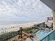 A balcony view with palm trees, beach umbrellas, pool and ocean in the background at 201 N Ocean Blvd. # 2536, Myrtle Beach, SC 29572