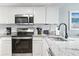 Modern kitchen with granite counters, stainless appliances, and white cabinets offers a clean, functional space at 205 74Th Ave. N # 1104, Myrtle Beach, SC 29572