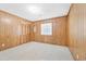 A vintage bedroom featuring wood paneled walls, neutral carpet, a window, and built in storage at 209 25Th Ave. N, North Myrtle Beach, SC 29582
