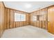 Bedroom featuring wood paneled walls, neutral carpet, a window, and a mirror on the wall at 209 25Th Ave. N, North Myrtle Beach, SC 29582