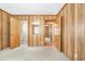 A vintage bedroom featuring wood paneled walls, neutral carpet, and multiple doorways to the bathroom at 209 25Th Ave. N, North Myrtle Beach, SC 29582
