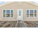 Close-up of the home's exterior featuring a front door flanked by matching glass windows and a wood deck at 209 25Th Ave. N, North Myrtle Beach, SC 29582