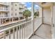 Condo balcony with white railings overlooking a parking lot and palm trees at 209 Hillside Dr. N # 104, North Myrtle Beach, SC 29582
