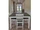 The dining room features a dining table with white wood chairs and a view through the double doors to the outdoors at 214 Carolina Dr., Loris, SC 29569