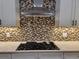 The kitchen features a stainless steel hood, mosaic tile backsplash, and sleek cooktop at 214 Carolina Dr., Loris, SC 29569