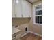 Bright laundry room features built-in cabinets, counter, and a window to offer a practical and organized space at 214 Carolina Dr., Loris, SC 29569