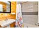 Bathroom featuring a sink, toilet, and shower with a floral patterned shower curtain and marble tiled walls at 219 27Th Ave. N, North Myrtle Beach, SC 29582