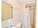 Brightly lit bathroom featuring a toilet, sink, shower with marble tile and patterned shower curtain at 219 27Th Ave. N, North Myrtle Beach, SC 29582