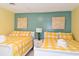 Bright bedroom featuring two beds with yellow checkered patterns and tasteful wall art at 219 27Th Ave. N, North Myrtle Beach, SC 29582