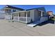 Side view of a quaint single-story home with a blue metal roof, featuring a welcoming front porch and ramp access at 219 27Th Ave. N, North Myrtle Beach, SC 29582