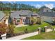 Aerial view of brick home's backyard with patio, mature trees, and a well-maintained lawn at 220 Waterfall Circle, Little River, SC 29566