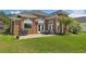 Brick home's manicured backyard features a patio with outdoor dining and a built-in grill for entertaining at 220 Waterfall Circle, Little River, SC 29566