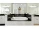Luxurious bathroom features a deep soaking tub, dual sinks with granite countertops, and decorative mirrors at 220 Waterfall Circle, Little River, SC 29566