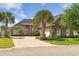 Beautiful brick home featuring lush landscaping, palm trees, and a brick driveway at 220 Waterfall Circle, Little River, SC 29566
